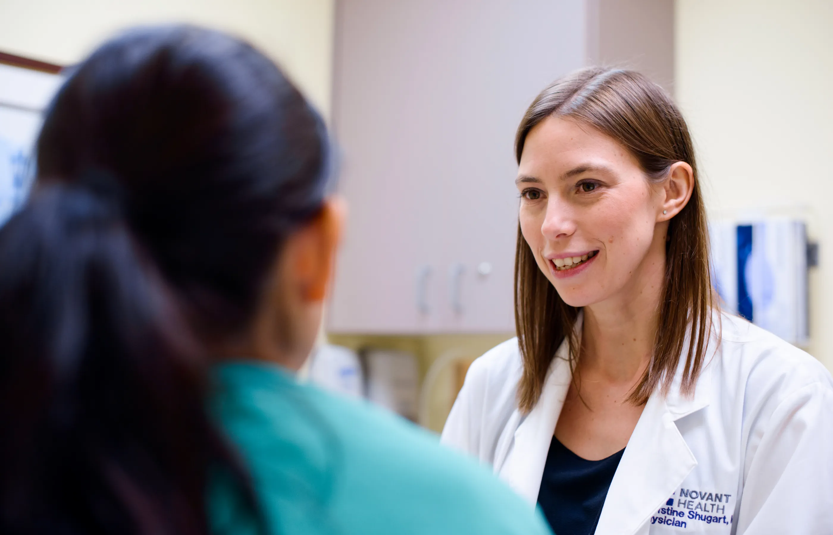 Dr. Shugart, a Novant Health physician, is talking with a patient as they sit in the exam room.